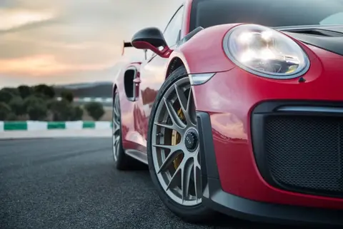 A red Porsche 911 GT2 RS shown low and close on a race track apron at sunset, from the same 2017 press launch as the car's Nürburgring record run