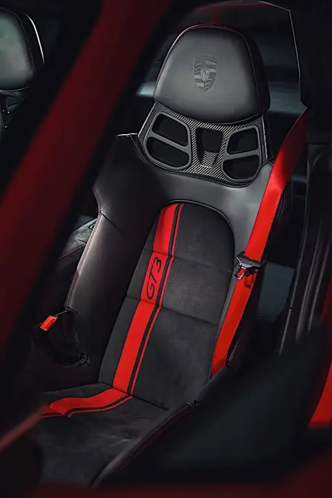 The black and red racing seat and rear roll cage inside a 991.2 Porsche 911 GT3, from the generation that brought the manual gearbox back