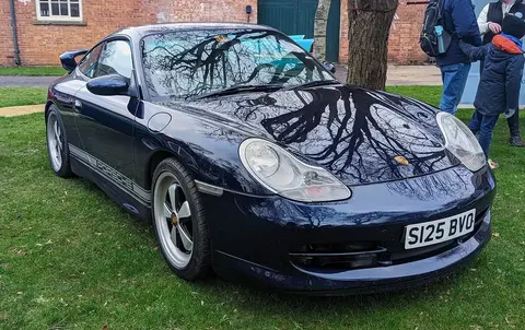 A 1998 Porsche 911 Carrera photographed outdoors, from the 996 generation that introduced Porsche's POSIP side-impact airbag system.