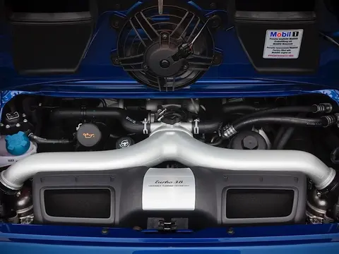 The open engine bay of a Porsche 911 Turbo 997.2, showing the new 3.8 litre direct fuel injection flat six with its variable turbine geometry turbochargers