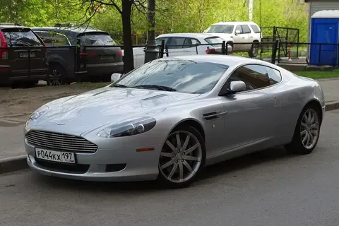 An Aston Martin DB9 coupe shown front three-quarter, the grand tourer that launched the VH platform used for a decade.