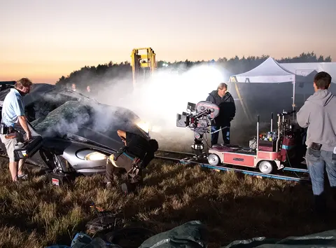 Behind the scenes of the Casino Royale barrel-roll stunt, showing the cannon-rigged Aston Martin DBS and film crew on location.