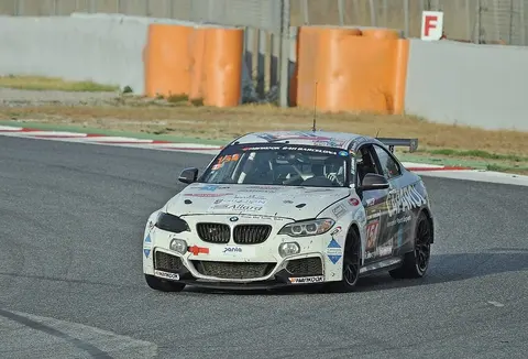 A BMW M235i Racing car in Team QSR Racingschool livery competing at the 24 Horas de Barcelona endurance race in 2017.
