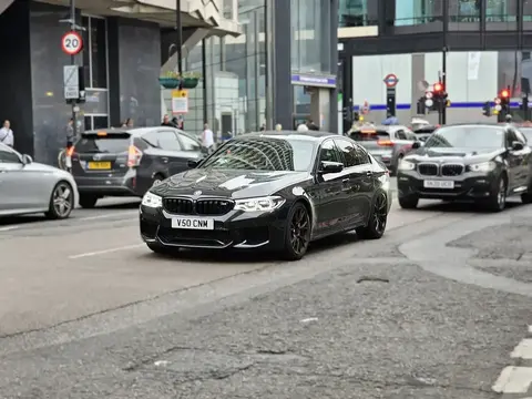A dark blue BMW M5 Competition F90 sedan, the first M5 generation offered with an xDrive all-wheel-drive system.