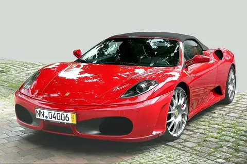 A Ferrari F430 parked outdoors, the model that introduced the steering-wheel manettino dial developed with Formula One input.