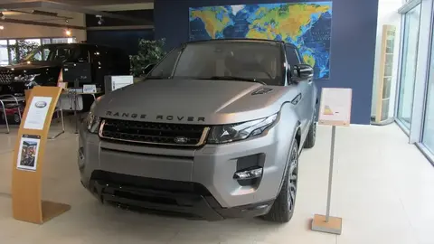 The matte-grey Range Rover Evoque Victoria Beckham Special Edition on a dealer showroom floor, front three-quarter view.