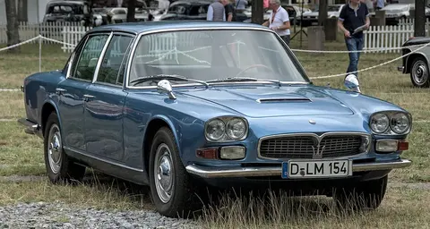 A first-generation Maserati Quattroporte at a classic car gathering, the Pietro Frua-styled original from 1963 that started the nameplate.