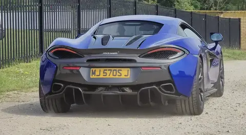A blue McLaren 570S photographed from directly behind, showing its rear diffuser and taillights.