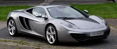A McLaren MP4-12C photographed from a low front angle on a city street.