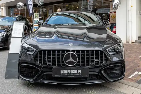 A silver Mercedes-AMG GT parked on a street at a classic car meet.