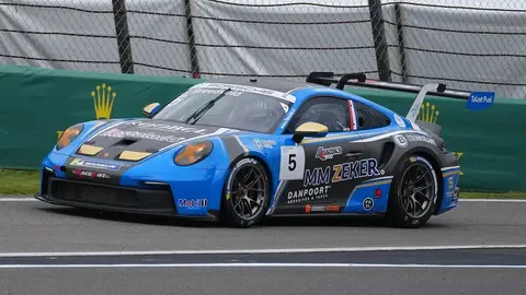 A white and orange Porsche 911 GT3 Cup racing at the Carrera Cup Benelux round at Spa-Francorchamps.